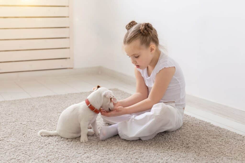 A child with her pet dog on the floor