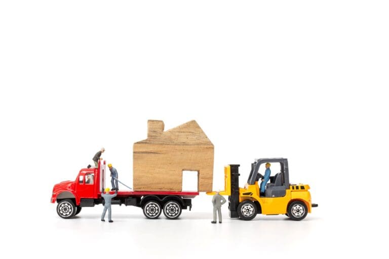 Miniature people, truck, and house figurine in the concept of relocation