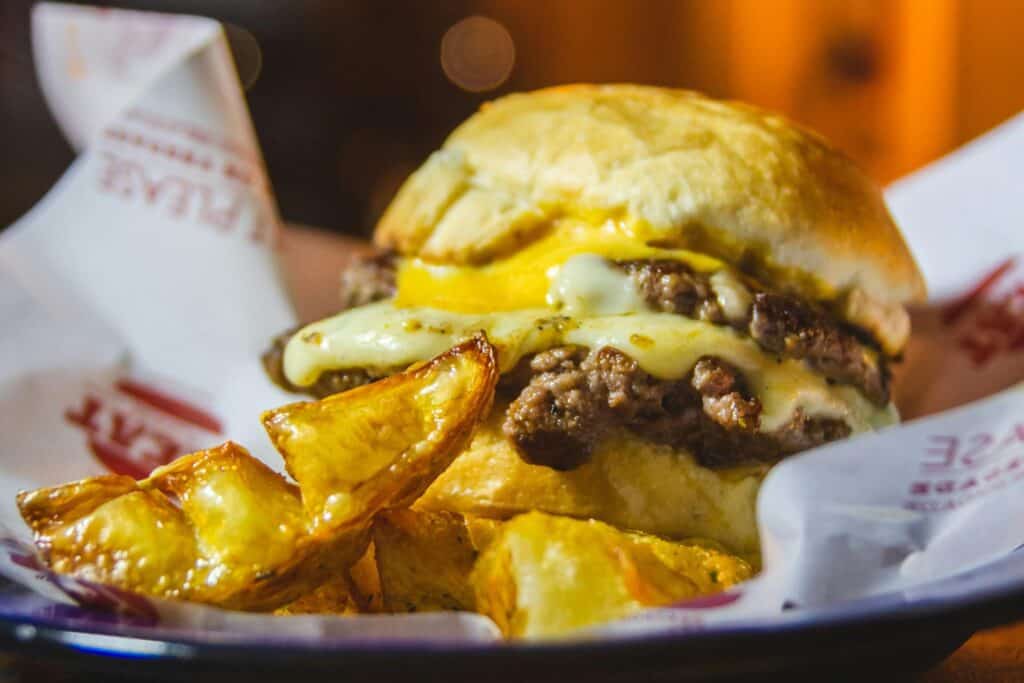 A closeup of a burger with chips on a plate - a quick meal during the moving day.