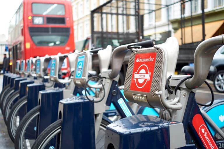 Santander bikes and a double-decker in the background in the concept of 'how to use Uxbridge's public transport'.